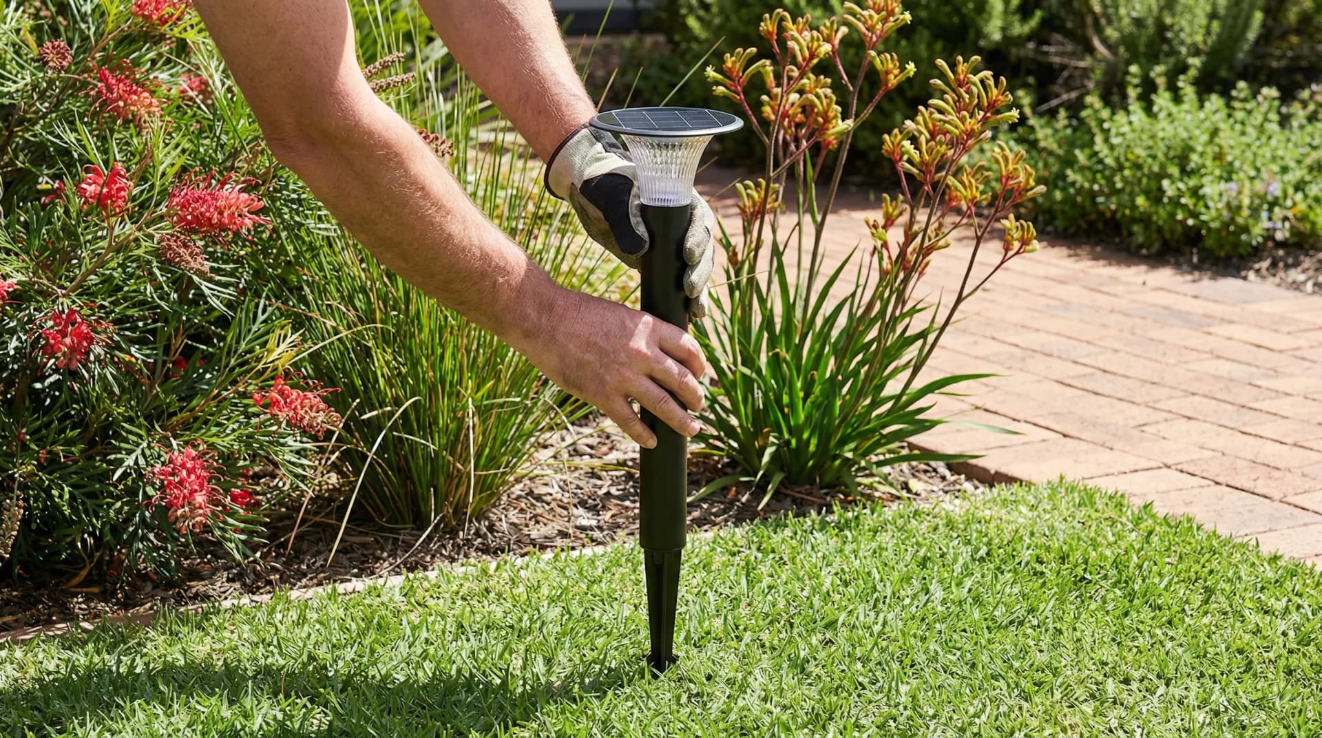 Solar bollard light being installed on residential garden pathway without trenching or cabling